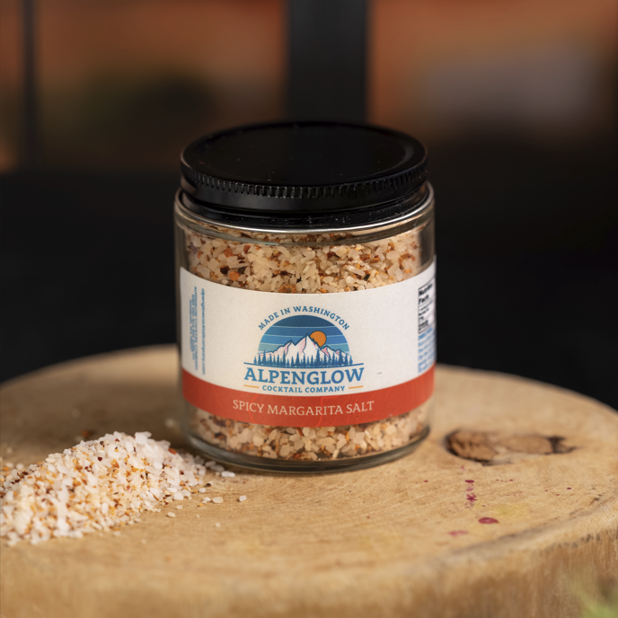 Jar of Alpenglow Spicy Margarita Salt on a wooden surface with a blurred background
