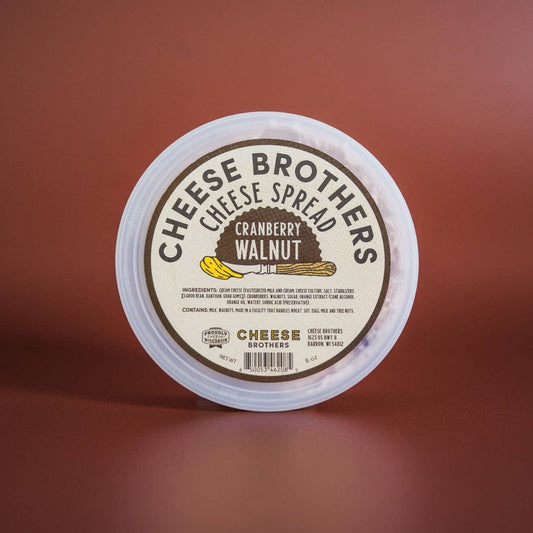 Container of Cheese Brothers Cranberry Walnut cheese spread on a brown background