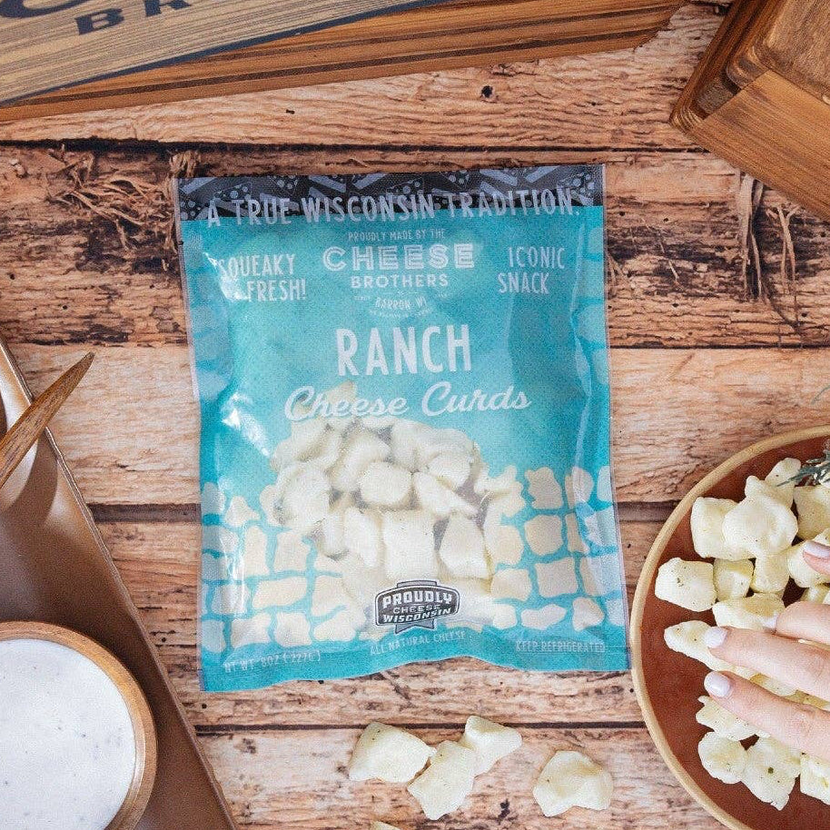Cheese balls with ranch seasoning on a wooden table, surrounded by decorative elements.