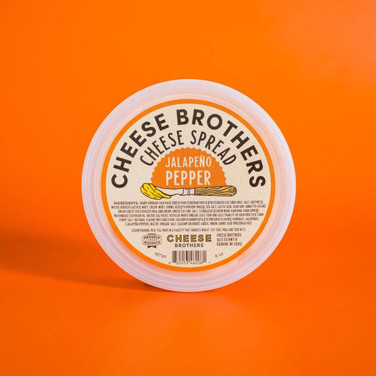 Container of Cheese Brothers Jalapeno Pepper cheese spread on an orange background
